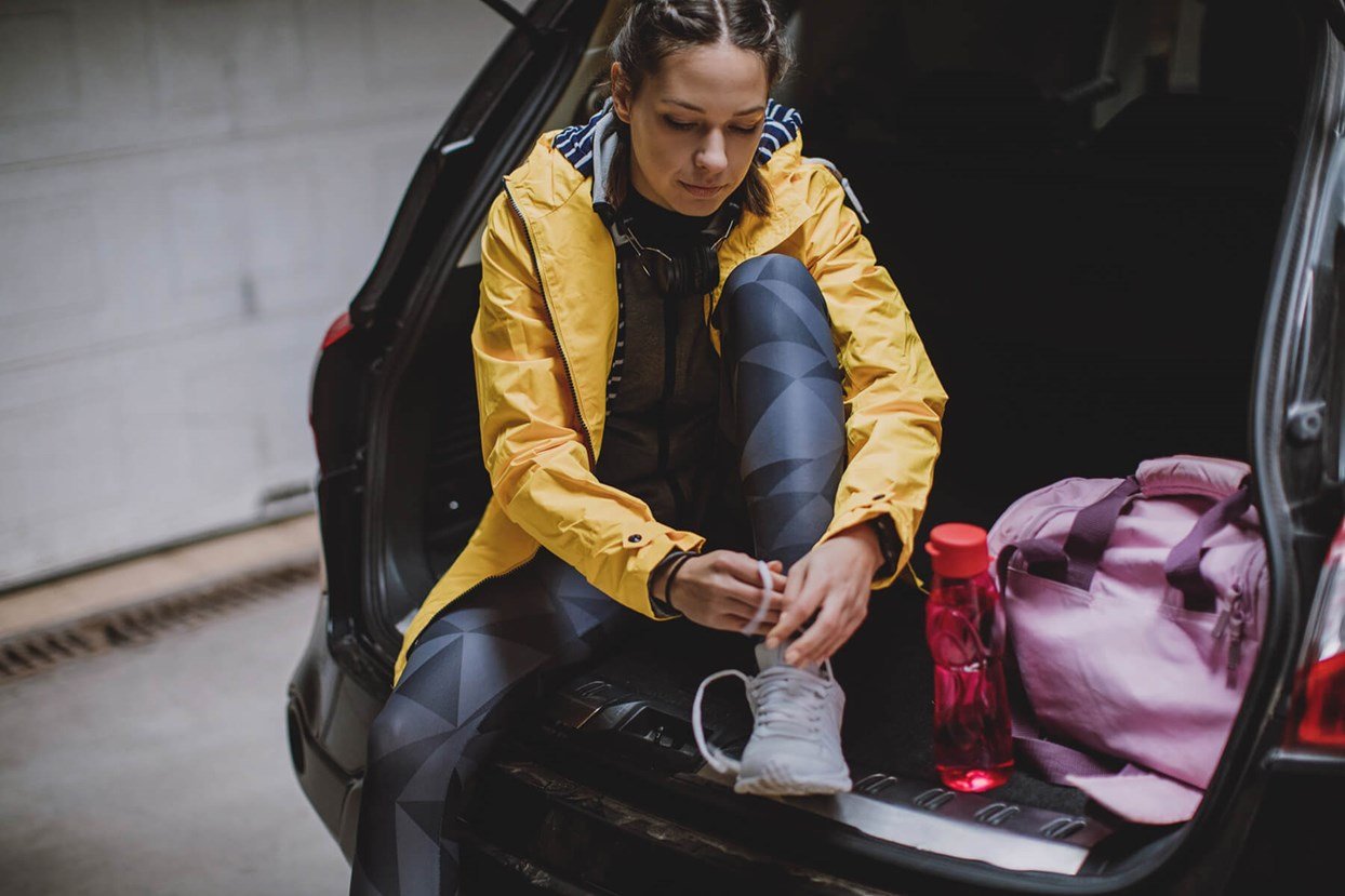 Bild av kvinna som byter om till träningskläder i bilen